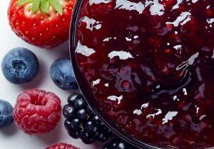 Bowl of wild berry jam isolated on white background from top view